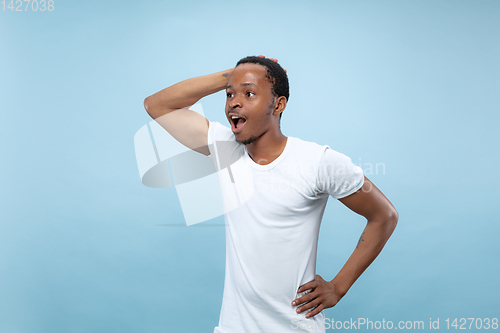 Image of Half-length close up portrait of young man on blue background.