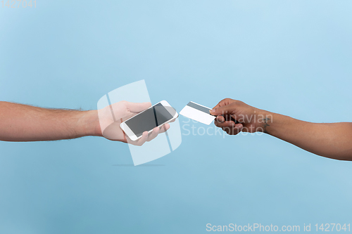 Image of Close up shot of human holding hands isolated on blue studio background.