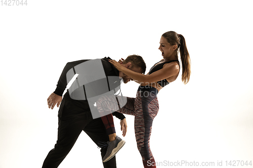 Image of Man and woman fighting in studio, women\'s self-defense concept