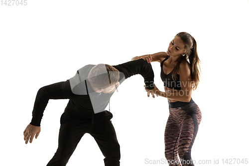 Image of Man and woman fighting in studio, women\'s self-defense concept