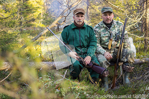 Image of Two older hunters rest
