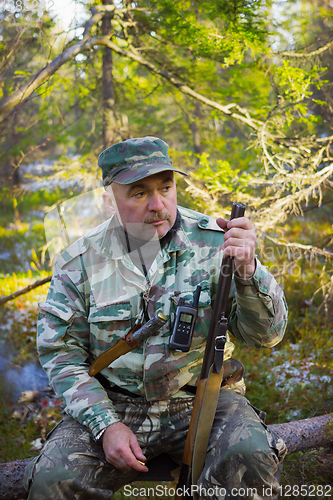 Image of Hunter resting, sitting on a log