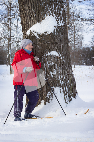 Image of Woman retirement age, walking in winter forest