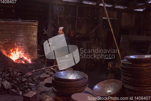 Image of young traditional Blacksmith working with open fire