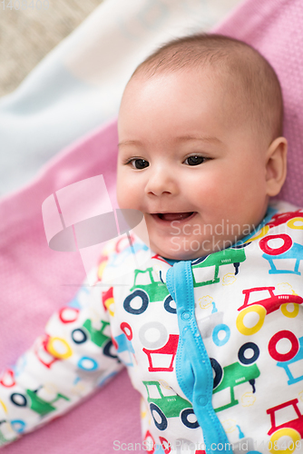 Image of top view of newborn baby boy lying on colorful blankets