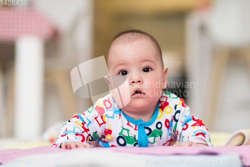 Image of newborn baby boy playing on the floor