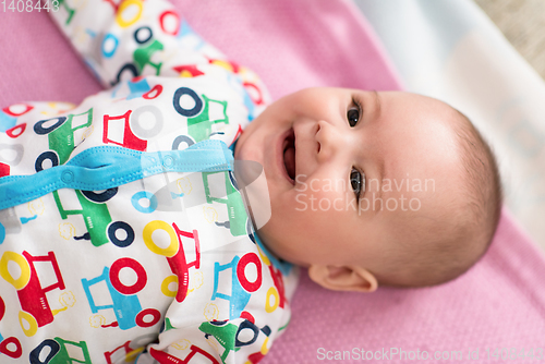 Image of top view of newborn baby boy lying on colorful blankets