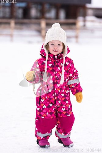 Image of little girl having fun at snowy winter day