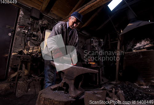 Image of blacksmith manually forging the molten metal