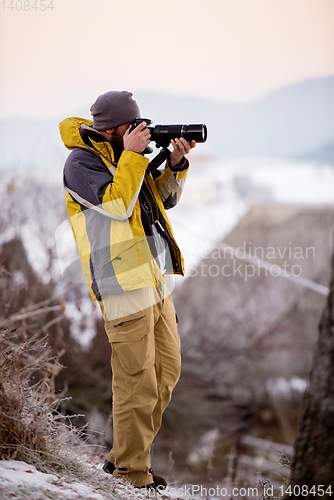 Image of male photographer taking photographs of winter forest