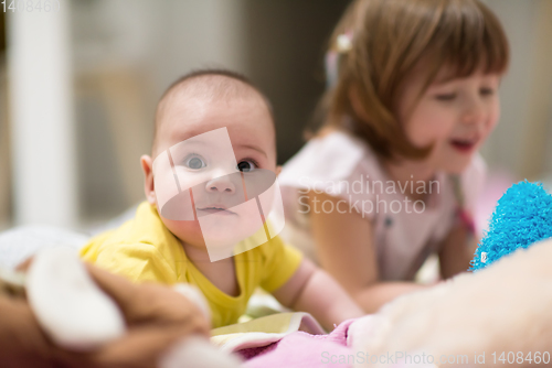 Image of little sister and her baby brother playing at home
