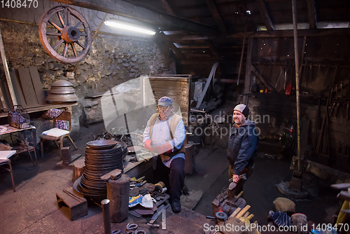 Image of portrait of two generations traditional blacksmith