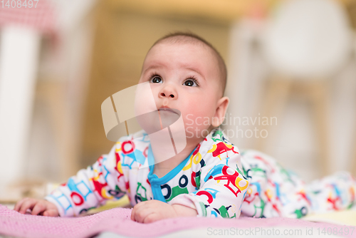 Image of newborn baby boy playing on the floor