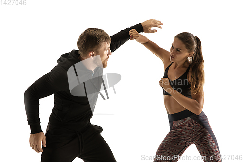 Image of Man and woman fighting in studio, women\'s self-defense concept