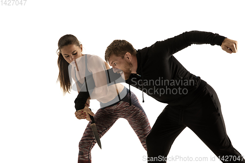 Image of Man and woman fighting in studio, women\'s self-defense concept