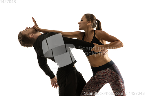 Image of Man and woman fighting in studio, women\'s self-defense concept