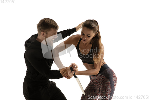 Image of Man and woman fighting in studio, women\'s self-defense concept