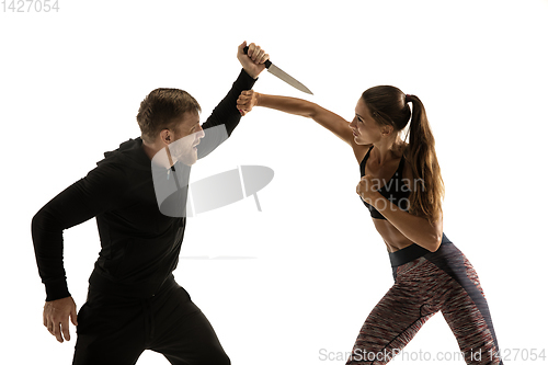 Image of Man and woman fighting in studio, women\'s self-defense concept