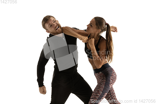 Image of Man and woman fighting in studio, women\'s self-defense concept