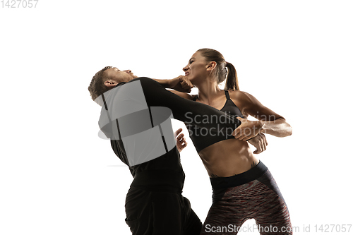 Image of Man and woman fighting in studio, women\'s self-defense concept