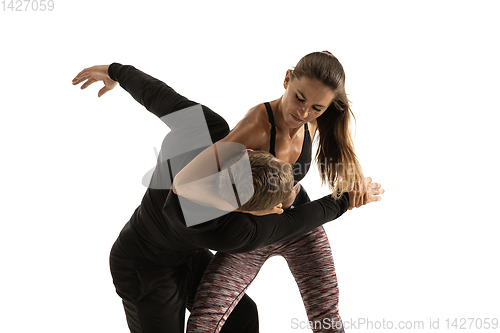 Image of Man and woman fighting in studio, women\'s self-defense concept