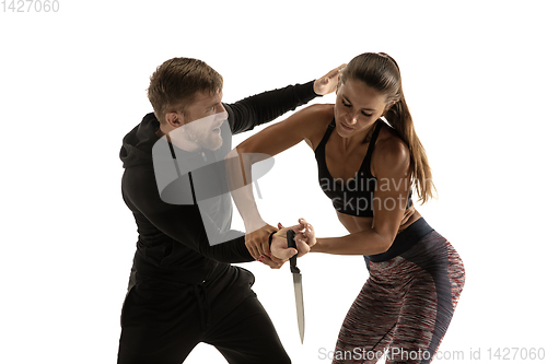 Image of Man and woman fighting in studio, women\'s self-defense concept