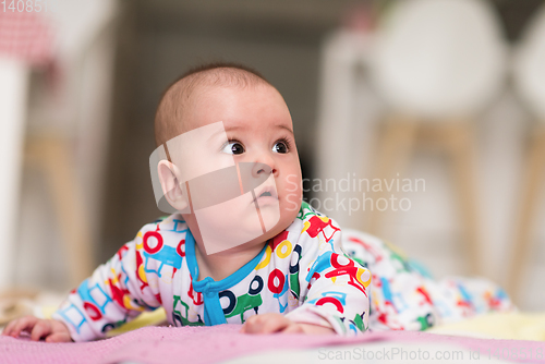 Image of newborn baby boy playing on the floor