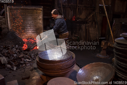 Image of young traditional Blacksmith working with open fire