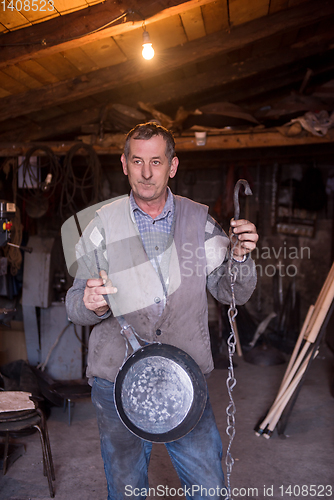 Image of A blacksmith worker showing handmade products ready for sale