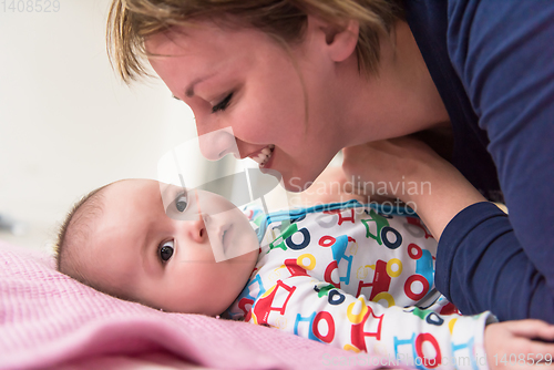 Image of young mother kissing her cute little baby