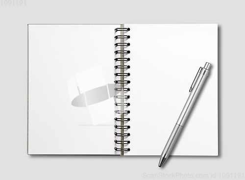 Image of Blank open spiral notebook and pen isolated on grey