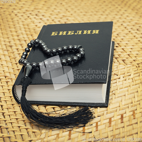 Image of Rosary on Bible put on a straw chair