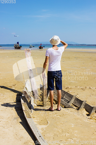 Image of Young stranger standing on the shattered boat