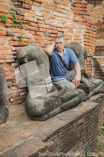 Image of Tourist thought, sitting on the ruins of an monastery, Thailand 