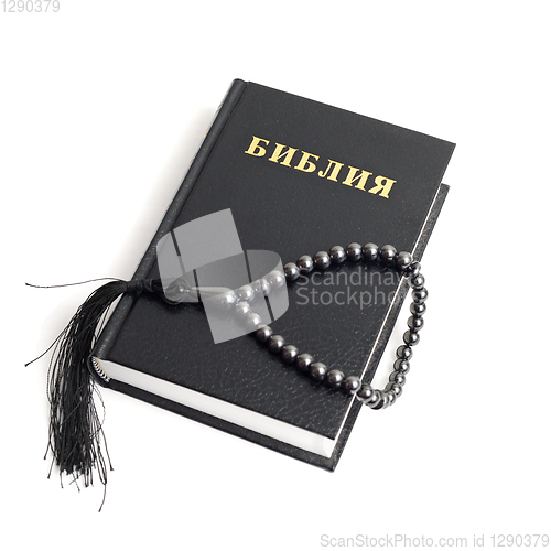 Image of Bible with rosary on white background