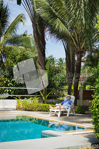 Image of Elderly tourist resting by the pool