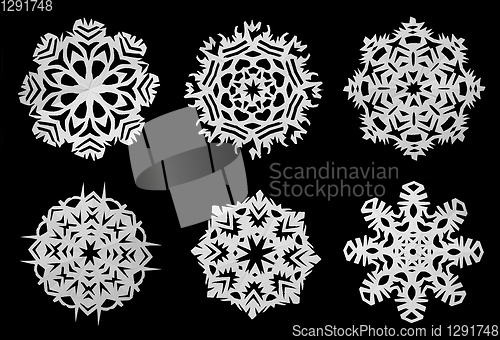 Image of Snowflakes cut out of white paper. Black background