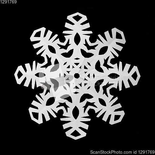 Image of Snowflake cut out of paper on a black background