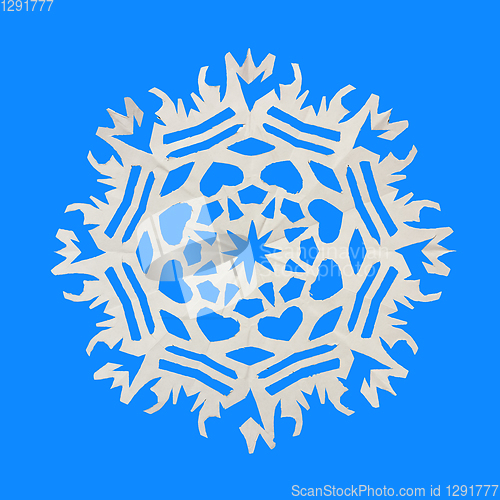 Image of On a blue background lie a paper snowflake