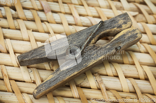 Image of Decrepit  wooden clothespin on straw mat