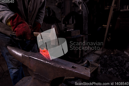 Image of blacksmith manually forging the molten metal