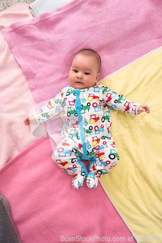 Image of top view of newborn baby boy lying on colorful blankets