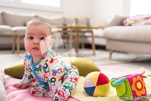 Image of newborn baby boy sitting on colorful blankets