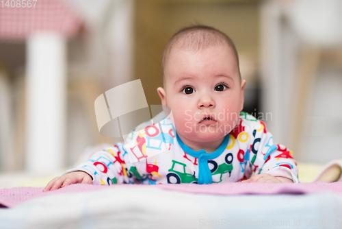 Image of newborn baby boy playing on the floor