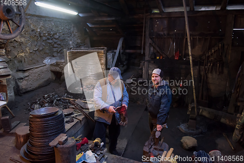 Image of portrait of two generations traditional blacksmith