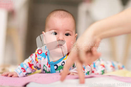 Image of newborn baby boy playing on the floor