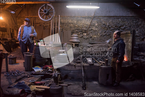 Image of portrait of two generations traditional blacksmith