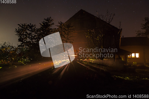 Image of the house with the burning window at night