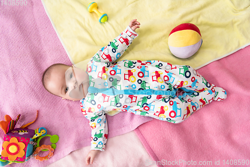 Image of top view of newborn baby boy lying on colorful blankets