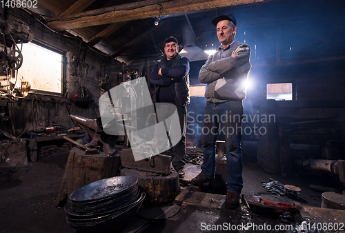 Image of portrait of two generations confident blacksmith